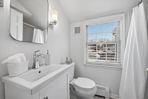 a bathroom with a toilet sink and mirror