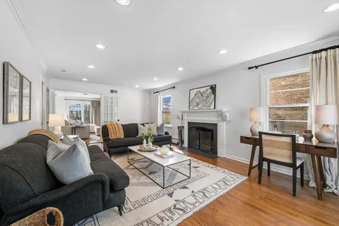 a living room with furniture a fireplace and a table