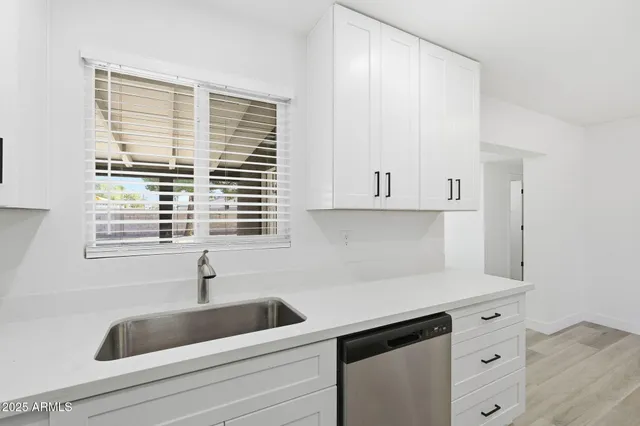 a kitchen with white cabinets and a sink