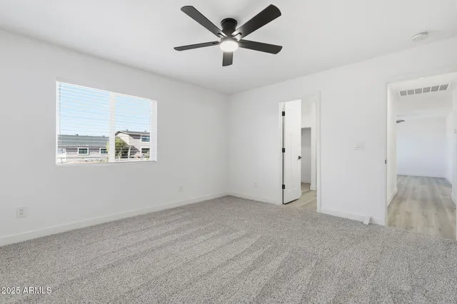 an empty room with fan and windows