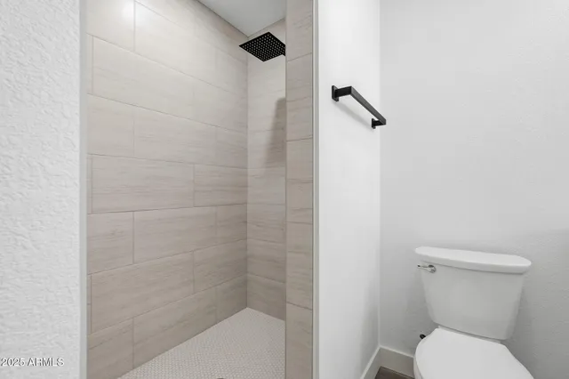 a white toilet sitting next to a shower