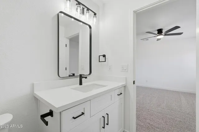 a bathroom with a sink a toilet and a mirror