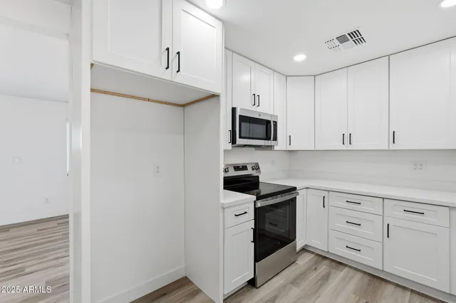 a kitchen with white cabinets and white appliances