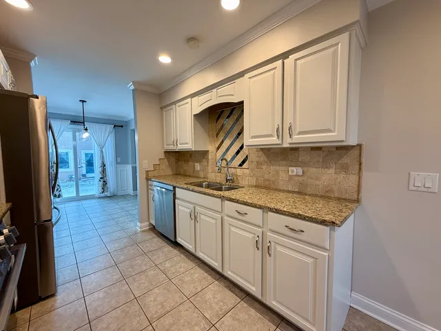 a kitchen with granite countertop a sink stove and refrigerator