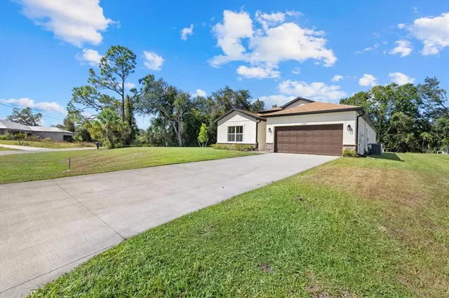 a front view of a house with a yard and garage