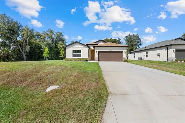 a front view of a house with a yard and trees