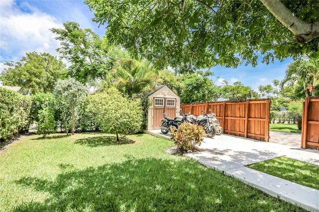 a view of a backyard with table and chairs and a small cabin