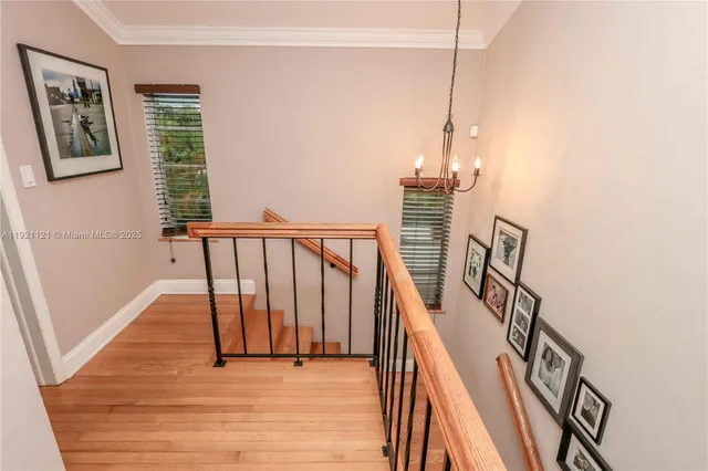 a view of a hallway with wooden floor and stairs