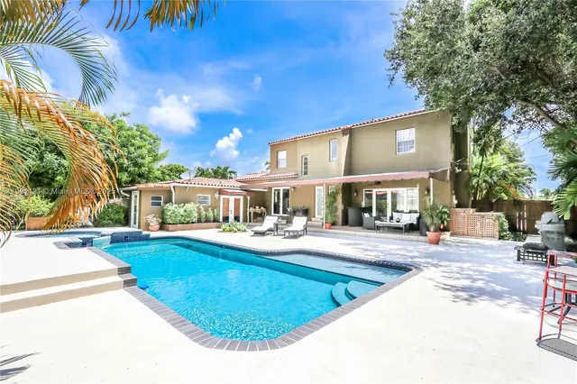 a view of a house with swimming pool and sitting area