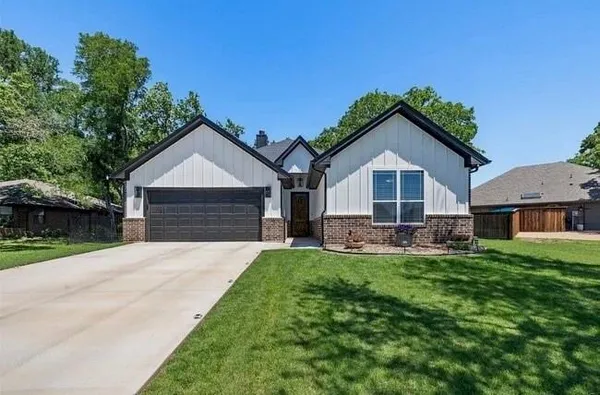 a front view of a house with a yard and trees