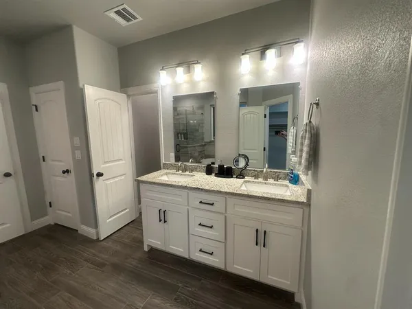 a bathroom with a double vanity sink and mirror