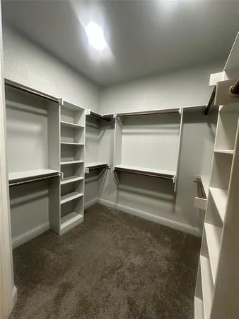 a view of walk in closet with empty racks
