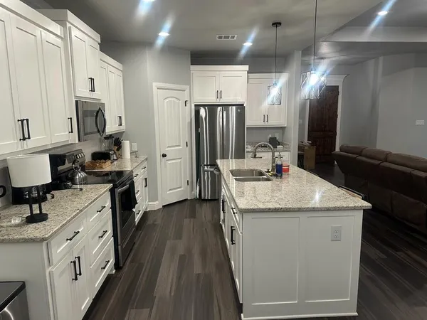 a kitchen with stainless steel appliances granite countertop a sink stove and refrigerator