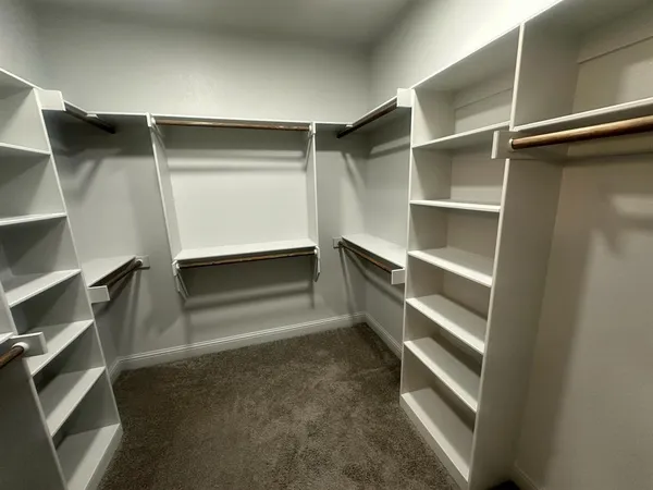 a view of walk in closet with empty racks