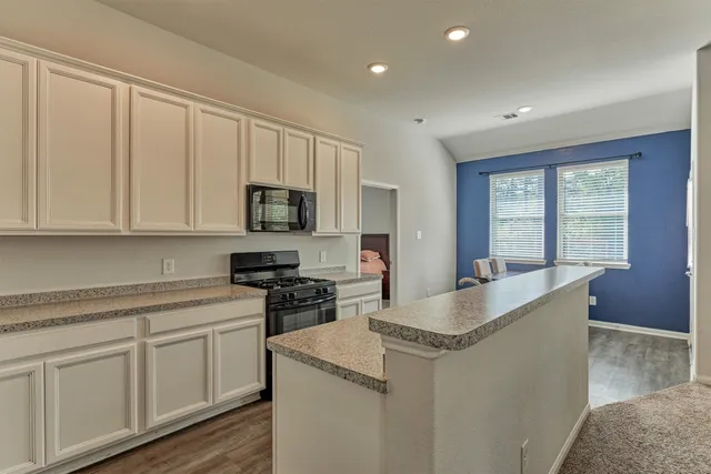 a kitchen with granite countertop white cabinets and a sink