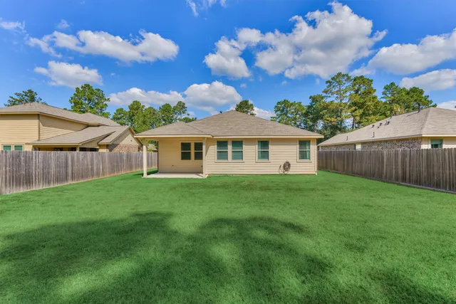 a view of a backyard with grass and a tree