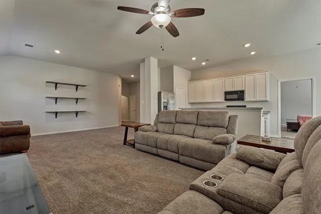 a living room with furniture and kitchen view
