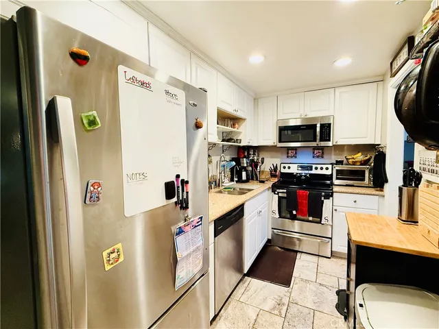 a kitchen with stainless steel appliances a refrigerator sink and microwave
