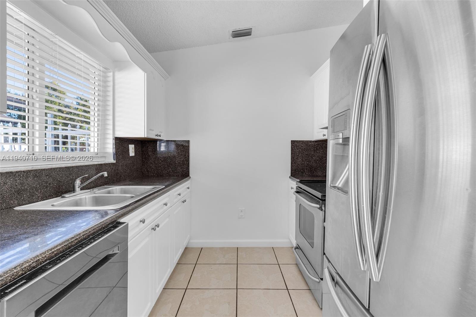 20900 Southwest 118th Avenue Miami, FL 33177 - Photo 8 of 41 a kitchen with a sink and a refrigerator