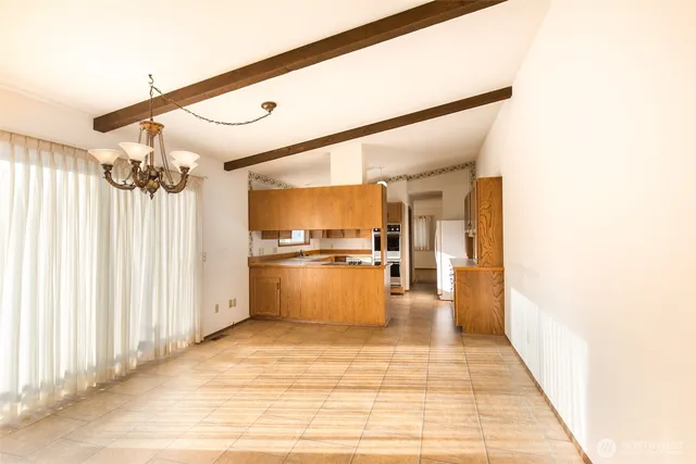 a kitchen with granite countertop a refrigerator and white cabinets