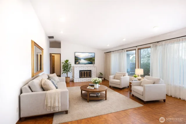 a living room with furniture fireplace and a large window