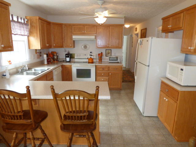 435 Endicott Hill Road Ferrum, VA 24088 - Photo 14 of 22 a kitchen with stainless steel appliances a refrigerator a sink a stove a dining table and chairs