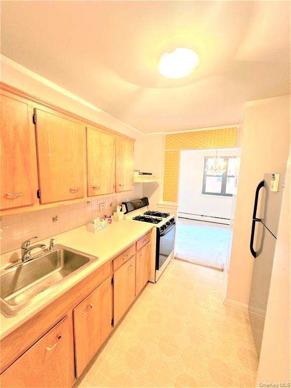 99-06 58th Avenue, Unit 3H Queens, NY 11368 - Photo 13 of 23 a large kitchen with a sink and cabinets