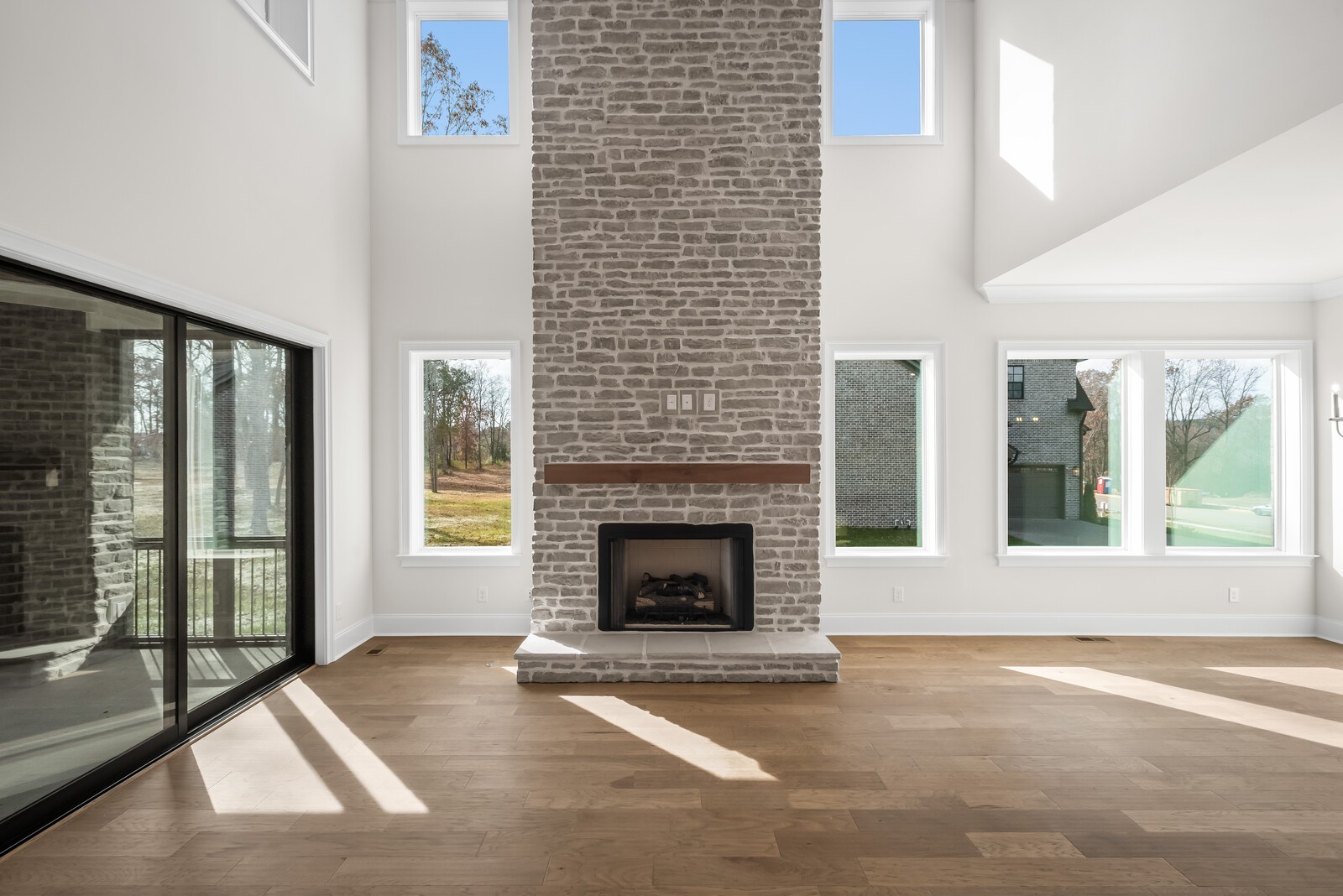 7221 Severide Street Fairview, TN 37062 - Photo 16 of 59 a living room with a fireplace and large windows