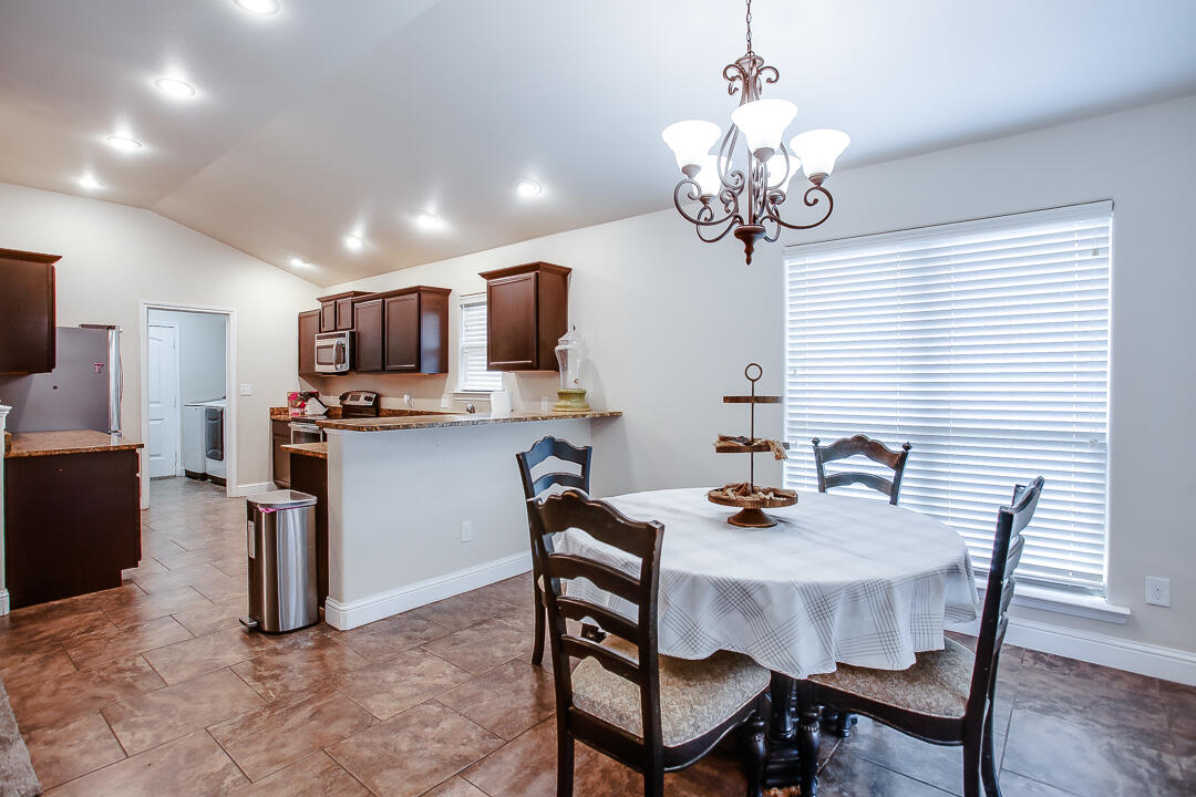 8804 Rochester Avenue Lubbock, TX 79424 - Photo 6 of 18 a dining room with furniture a chandelier and window