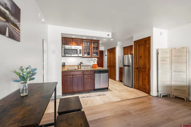 a kitchen with stainless steel appliances kitchen island granite countertop a refrigerator a stove and a sink