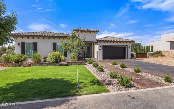 a front view of a house with a garden and yard