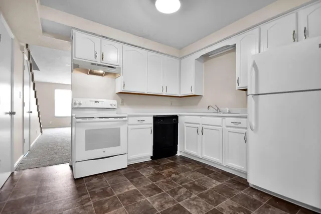 a kitchen with white cabinets and white appliances