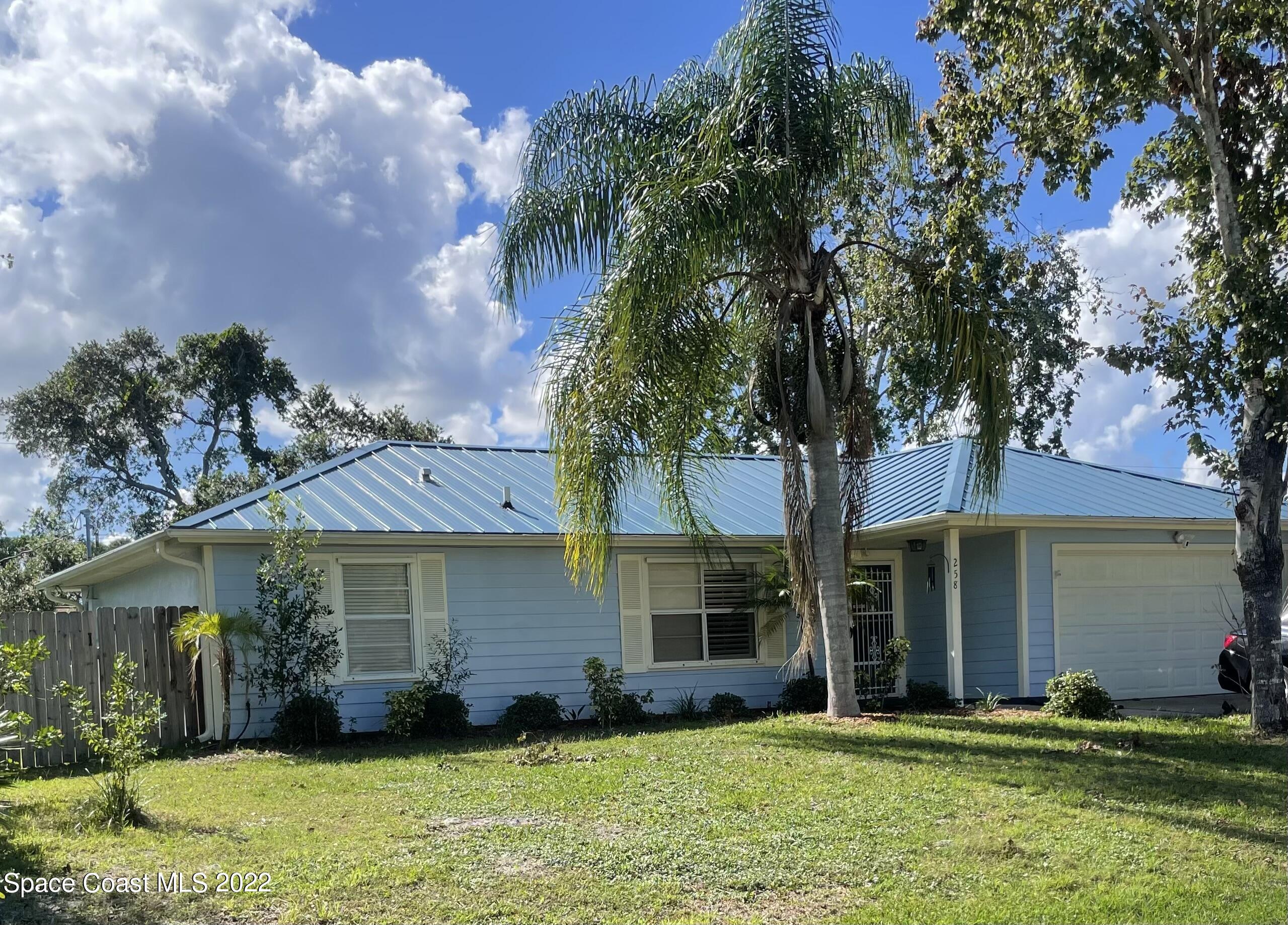 258 San Remo Road Southwest Palm Bay, FL 32908 - Photo 1 of 6 a front view of a house with a yard and garage