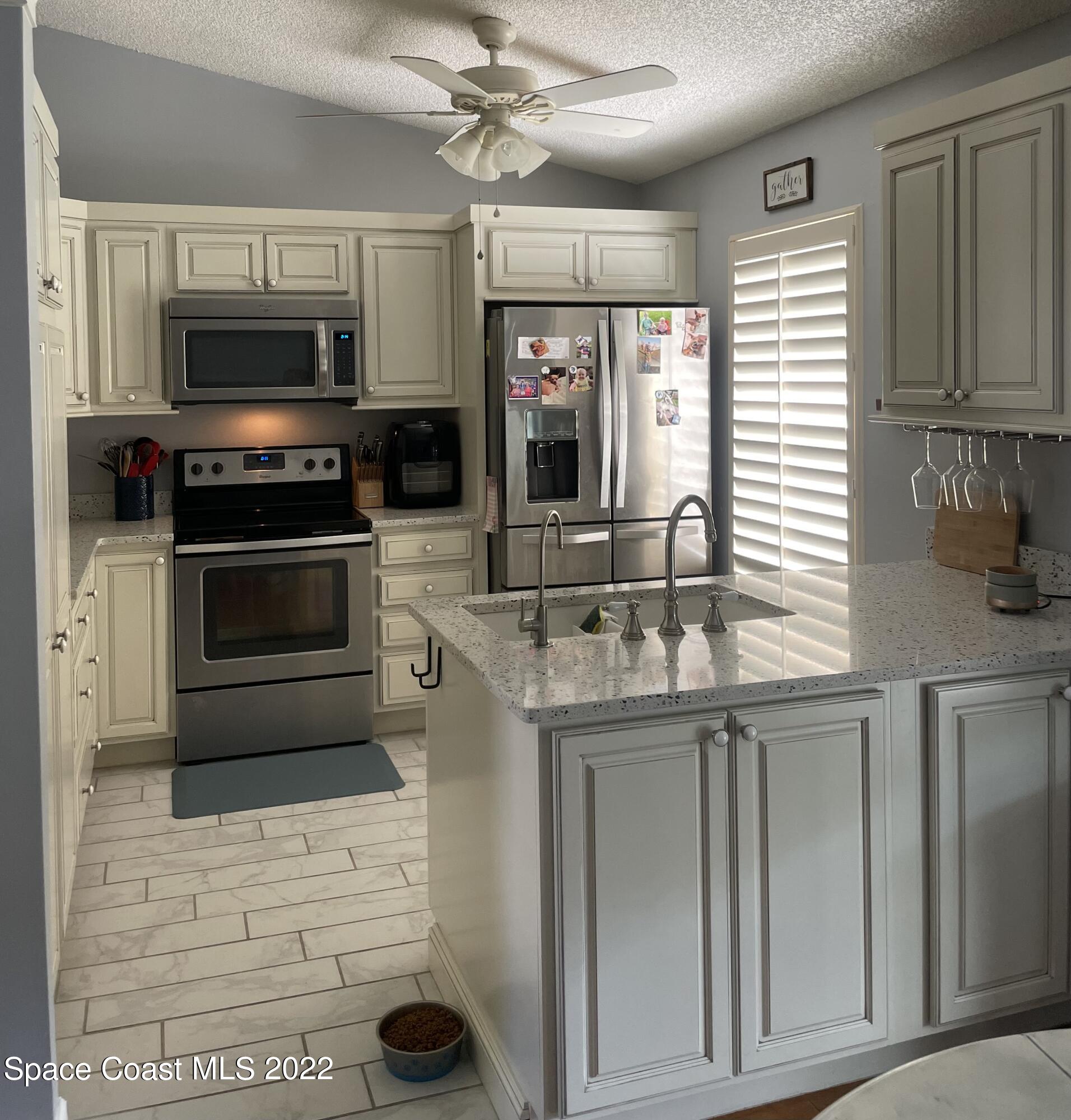 258 San Remo Road Southwest Palm Bay, FL 32908 - Photo 4 of 6 a kitchen with stainless steel appliances granite countertop a stove and a microwave