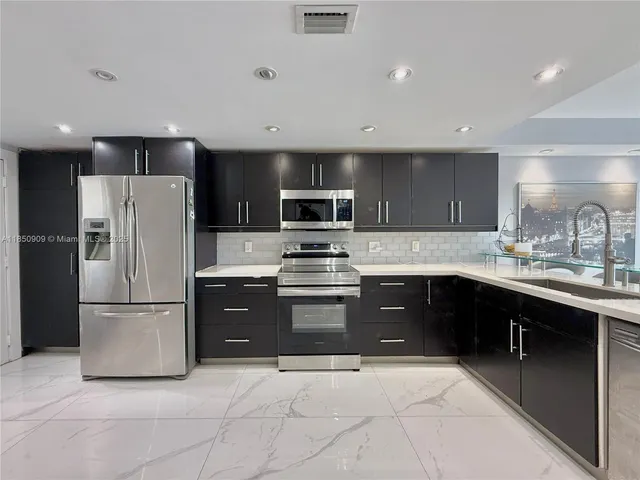 a kitchen with granite countertop a refrigerator and a sink