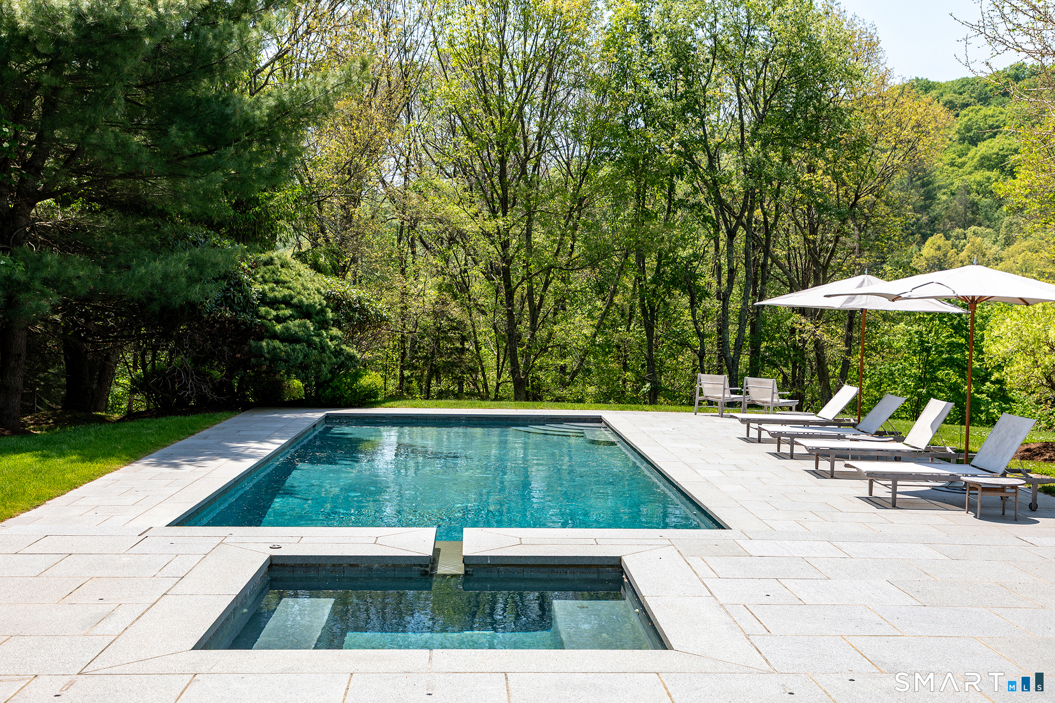 47 Squire Road Roxbury, CT 06783 - Photo 25 of 27 a view of a swimming pool with lawn chairs under an umbrella