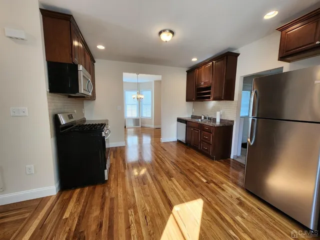 a kitchen with stainless steel appliances granite countertop a refrigerator a stove top oven a sink and dishwasher