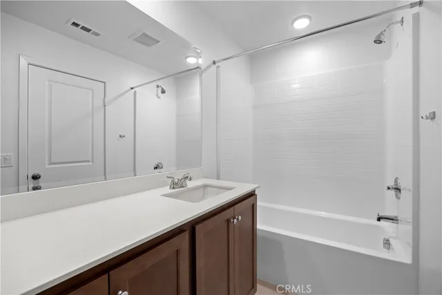 a bathroom with a sink double vanity mirror and a bathtub