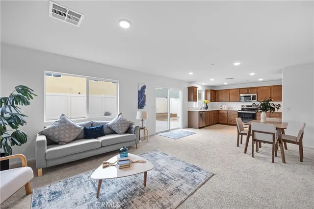 a living room with furniture and view of kitchen