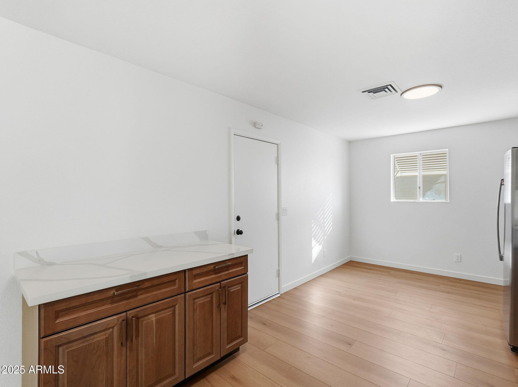 1428 South Palo Verde Drive Apache Junction, AZ 85120 - Photo 10 of 37 an empty room with wooden floor and cabinet