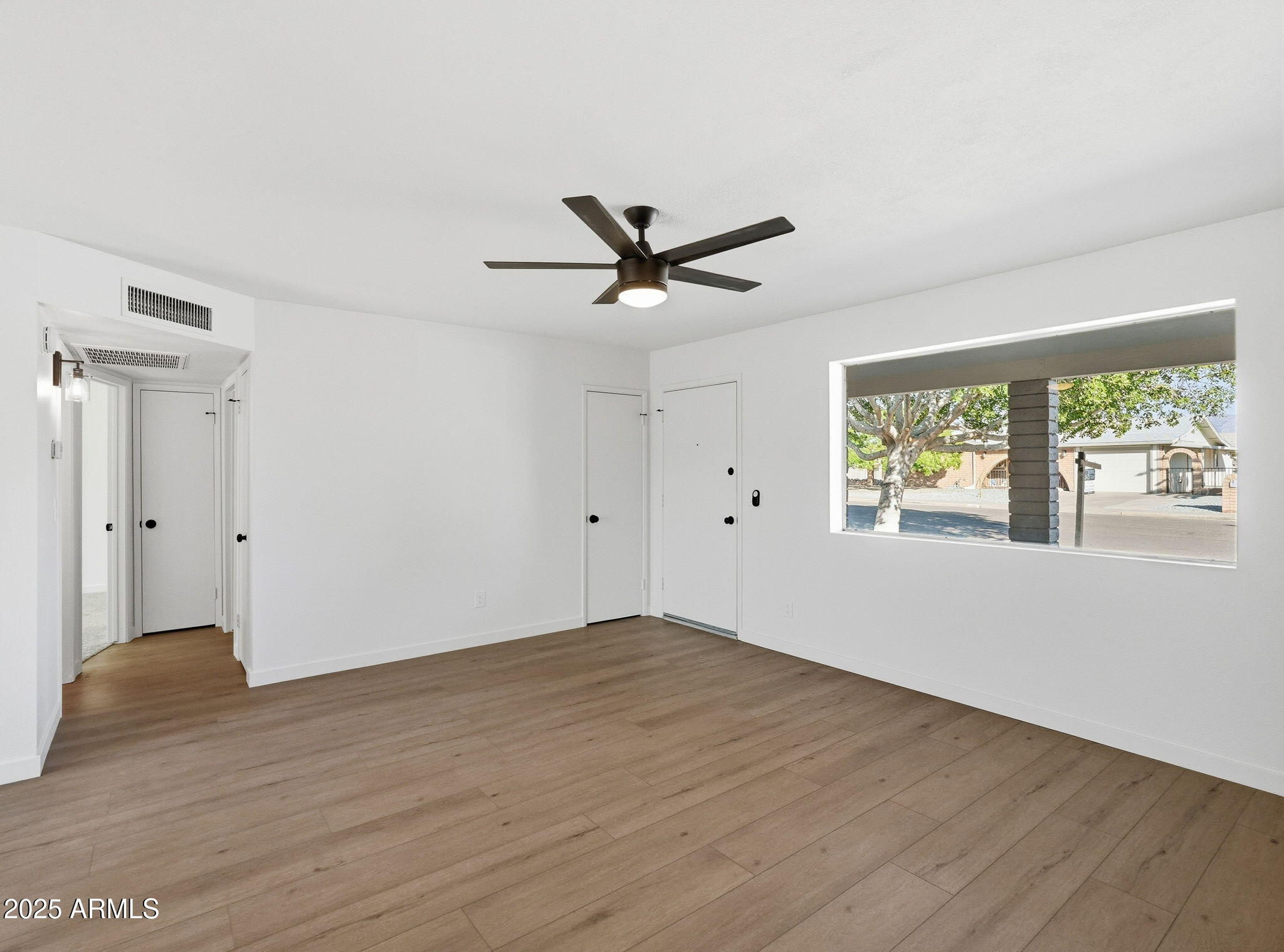 1428 South Palo Verde Drive Apache Junction, AZ 85120 - Photo 13 of 37 an empty room with wooden floor and windows