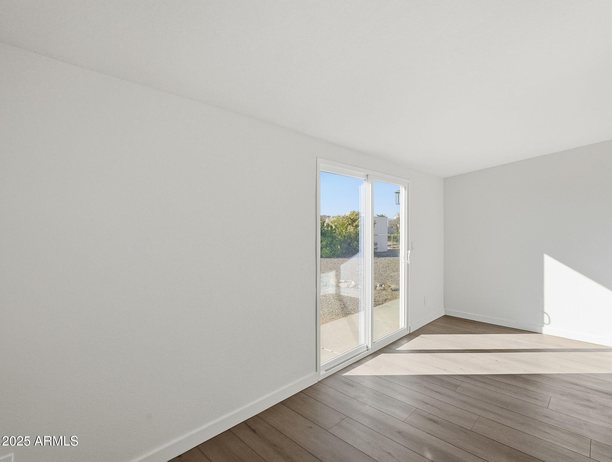 1428 South Palo Verde Drive Apache Junction, AZ 85120 - Photo 18 of 37 a view of an empty room with wooden floor and a window