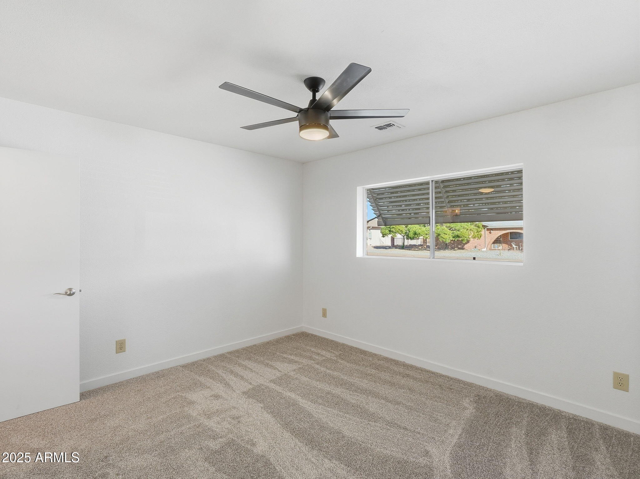 1428 South Palo Verde Drive Apache Junction, AZ 85120 - Photo 20 of 37 an empty room with a window and ceiling fan