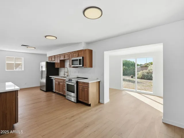 a large kitchen with stainless steel appliances granite countertop a stove a sink and a microwave