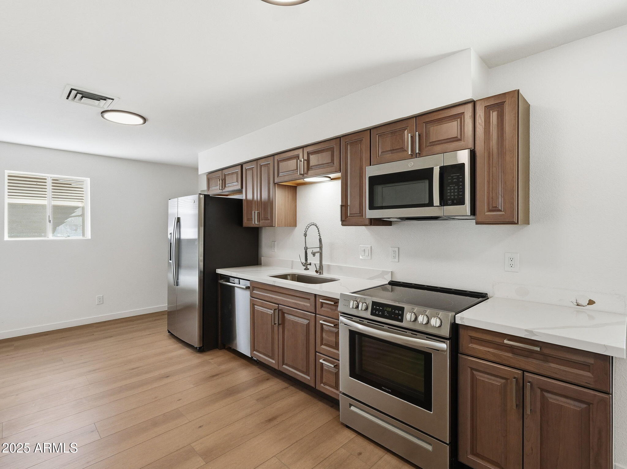 1428 South Palo Verde Drive Apache Junction, AZ 85120 - Photo 5 of 37 a kitchen with stainless steel appliances a stove microwave and sink