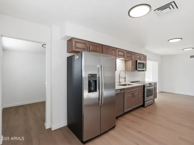 a modern kitchen with stainless steel appliances granite countertop a refrigerator and a sink