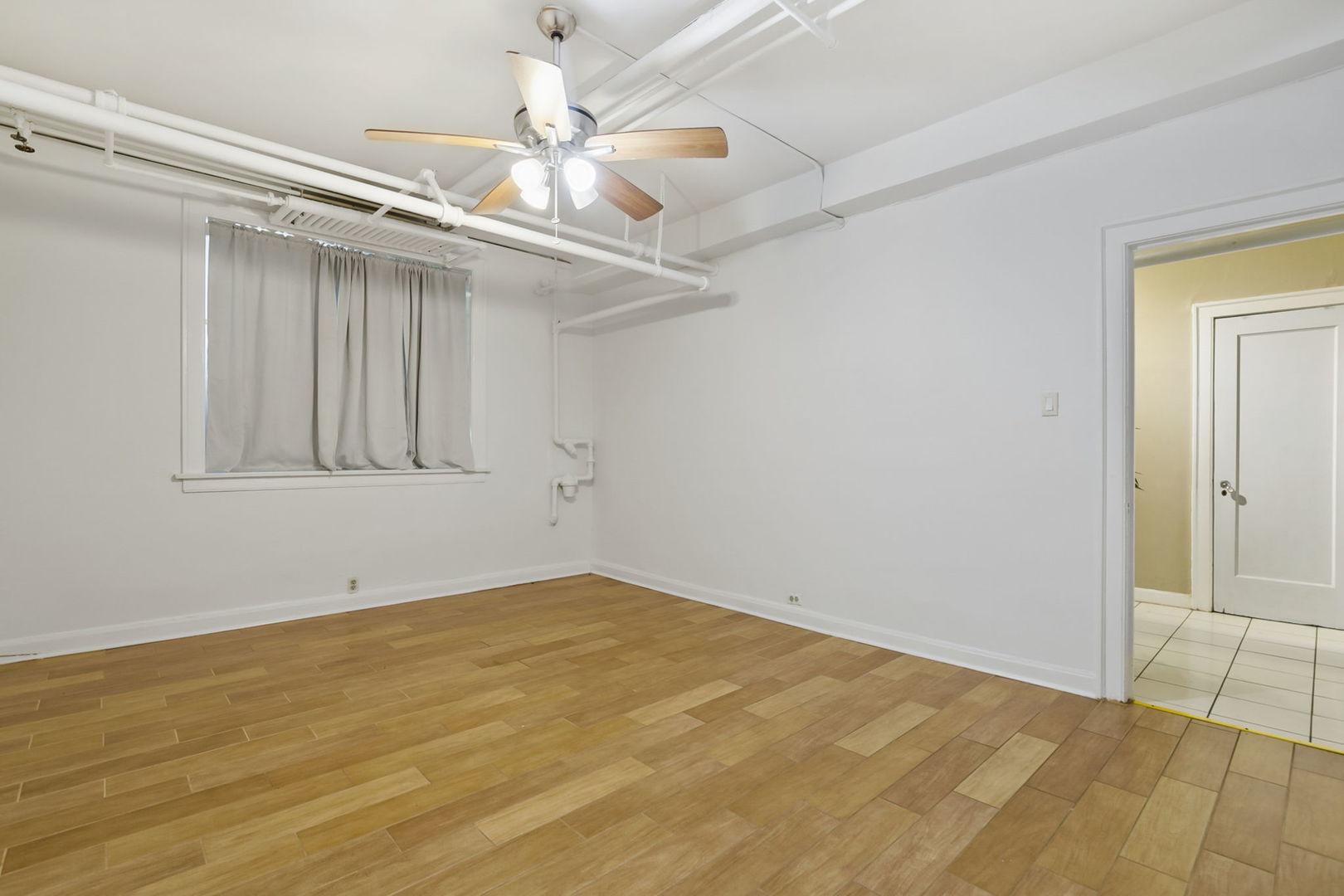 1360 East Madison Park, Unit B Chicago, IL 60615 - Photo 12 of 25 a view of empty room with wooden floor and fan