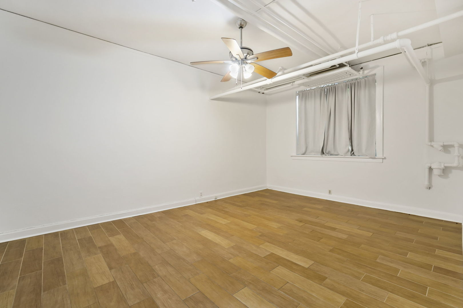 1360 East Madison Park, Unit B Chicago, IL 60615 - Photo 13 of 25 an empty room with wooden floor and windows