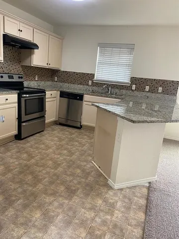 a kitchen with stainless steel appliances granite countertop a stove a sink and a microwave