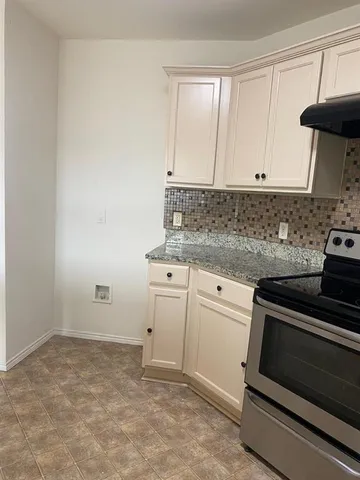 a kitchen with granite countertop white cabinets and white appliances